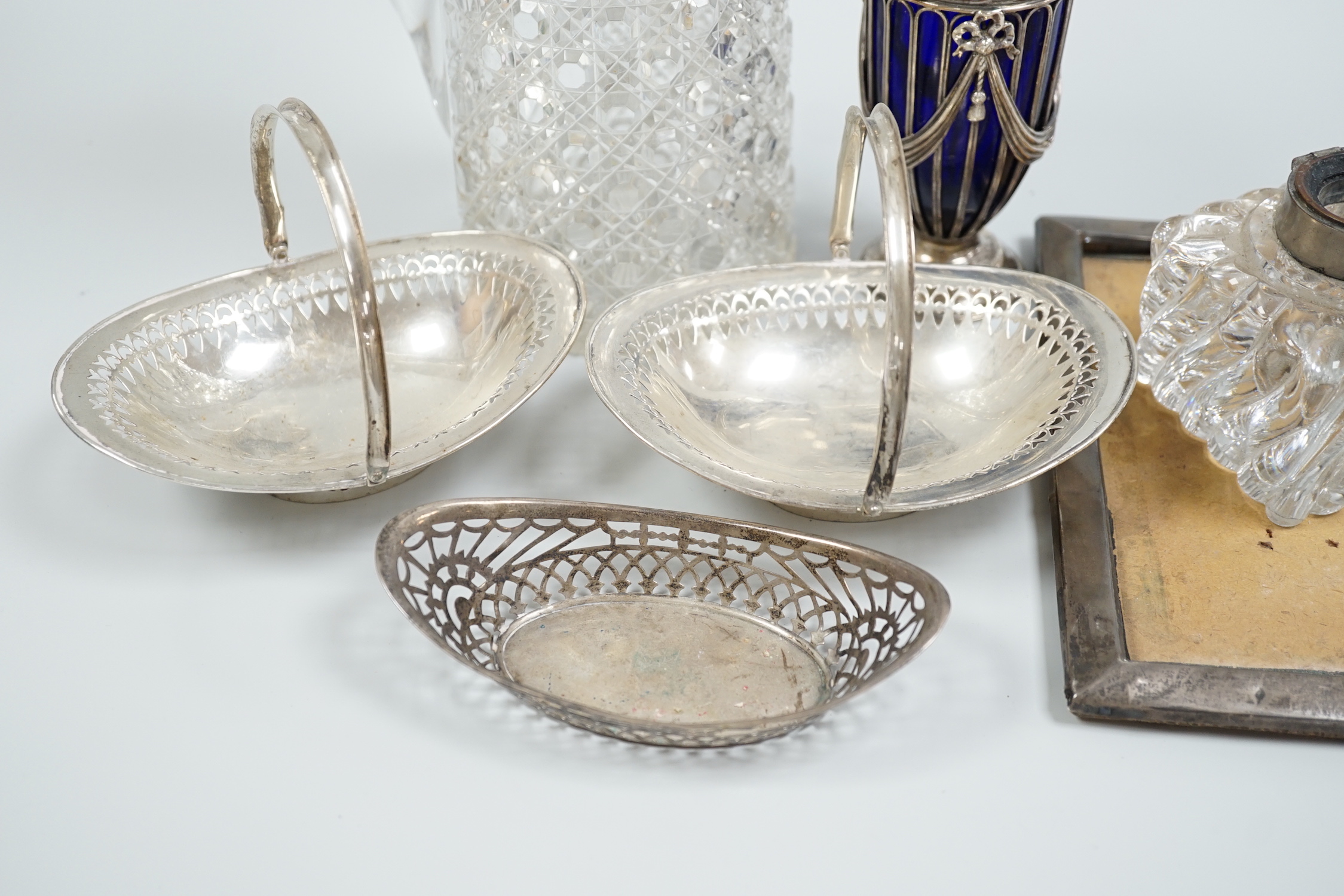 Sundry silver items including a Victorian silver mounted glass lemonade jug (a.f.), mounted glass sugar caster, damaged inkwell, photograph frame, pair of silver bonbon baskets and a small silver dish.